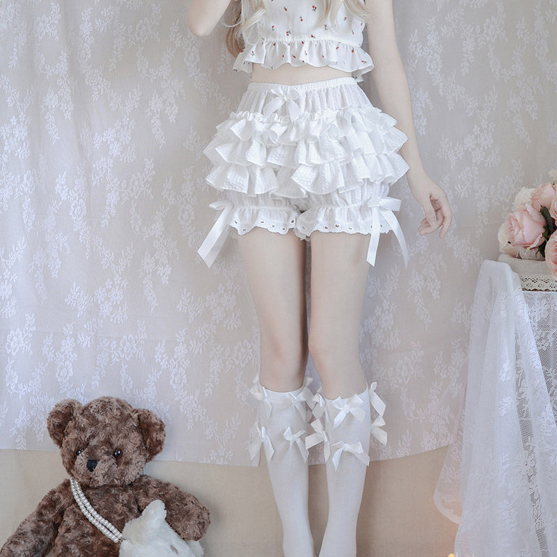 Frilly white layered skirt with matching ruffled top and knee-high socks.