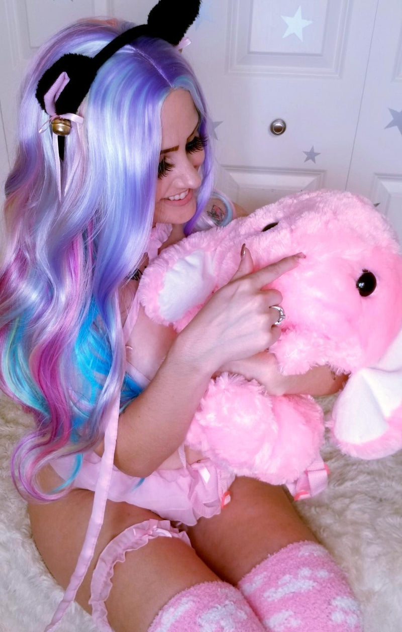 Pink plush elephant toy being hugged.